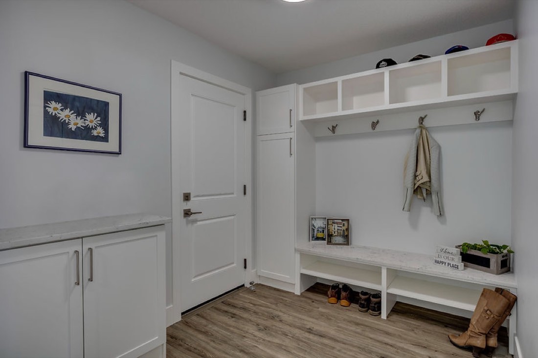 A generous storage area with coat hooks and a low cupboard.